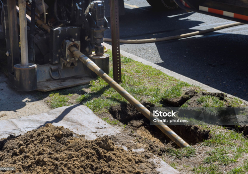 Low angle view of trenchless laying of communications, fiber optic and water pipes with horizontal directional drilling technology machine work process